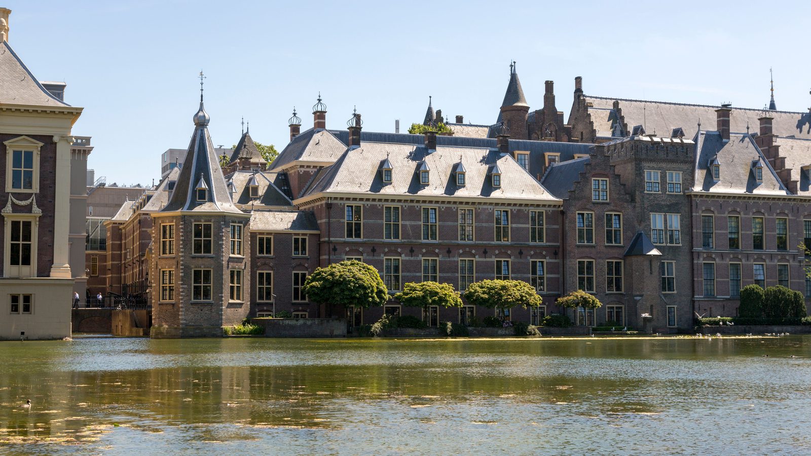 Het Binnenhof en de Hofvijver in Den Haag op een zonnige dag, de plek waar de Tweede Kamer en de Eerste Kamer over nieuwe wetten beslissen